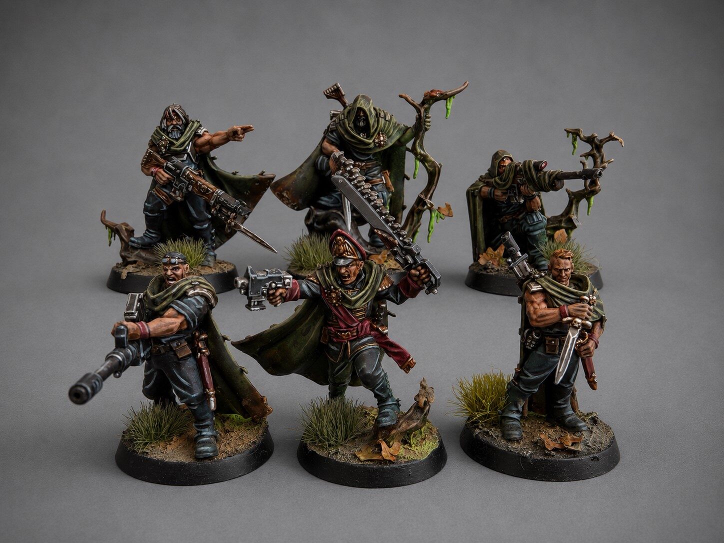 Hand-painted Gaunt's Ghosts Tanith squad miniatures in weathered camo greatcoats on a themed forest base, narrative commission by Alto Studio